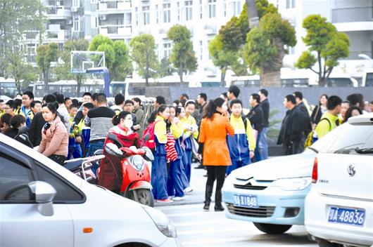 圖為：放學后，很多家長開車接孩子回家