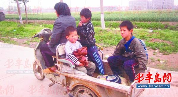 2011年底一名孩子在三輪車上趕作業。一年半過去了，這樣的場景仍隨處可見。