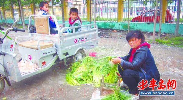 2011年底一名孩子在三輪車上趕作業。一年半過去了，這樣的場景仍隨處可見。