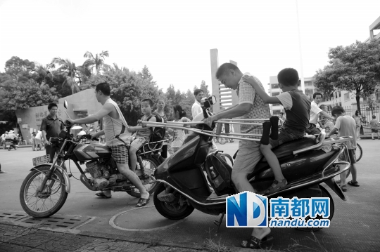 <p>因校車座位不夠，洪梅第二小學今年的新莞人新生不能坐校車，許多家長只能騎車接送孩子。南都記者劉在富攝<br /><br /></p>