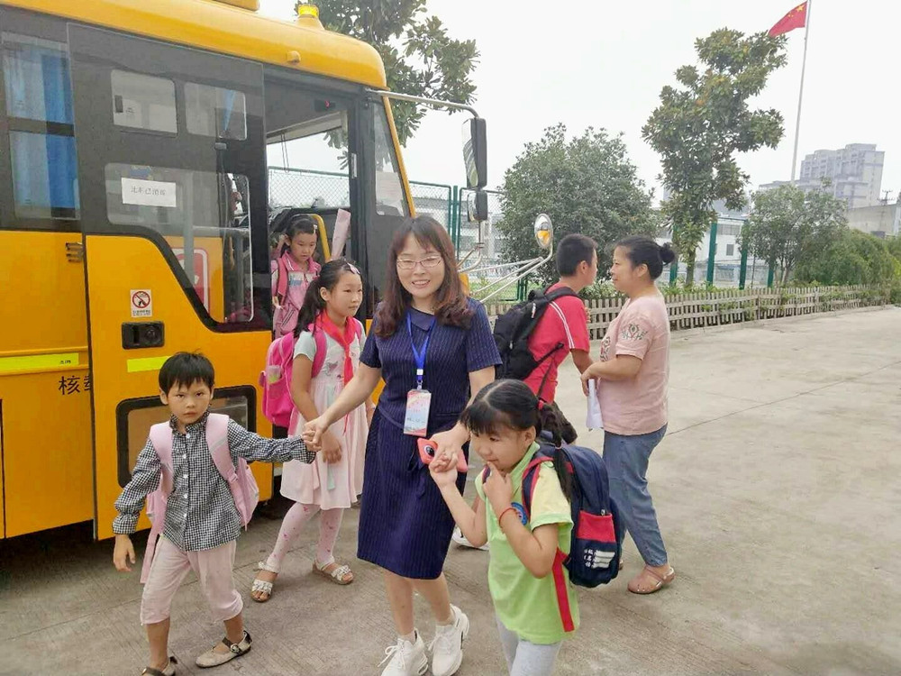 圖為校車照管員阿姨護送孩子上下學。