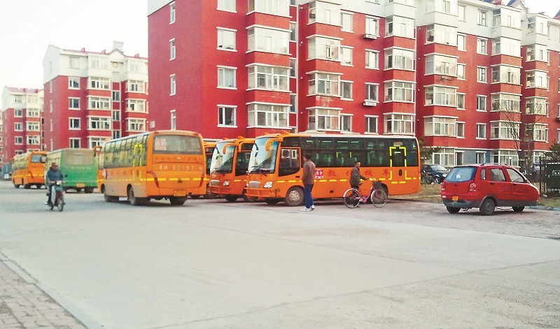 多輛校車停在黑輔導班樓前。