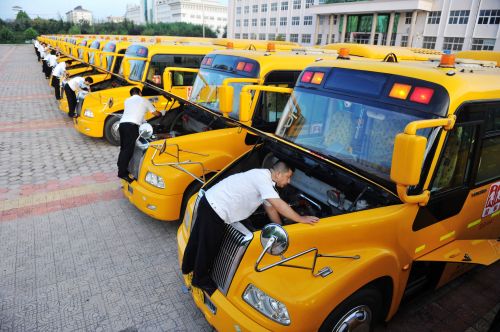 交運溫馨校車黃島分公司駕駛員在檢查和清理校車發(fā)動機。 (1)
